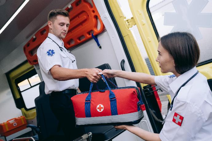 Ratownik przekazujący torbę medyczną innej osobie