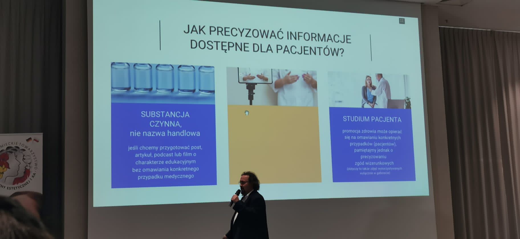 Zdjęcie przedstawiające kobietę wygłaszającą wykład, w tle prezentacja i słuchacze